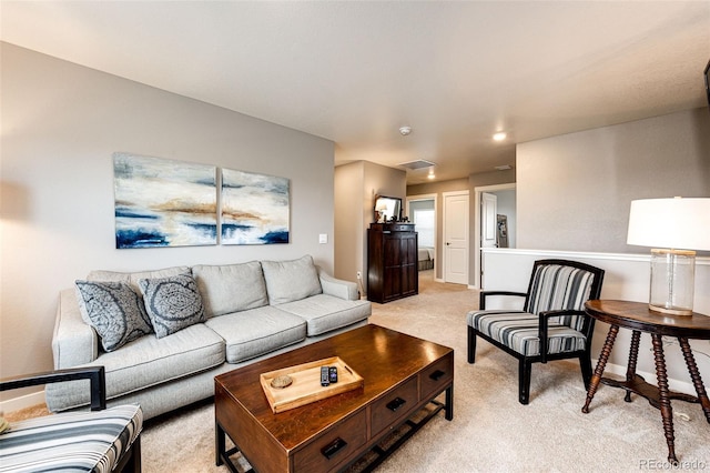 living area featuring light carpet and baseboards