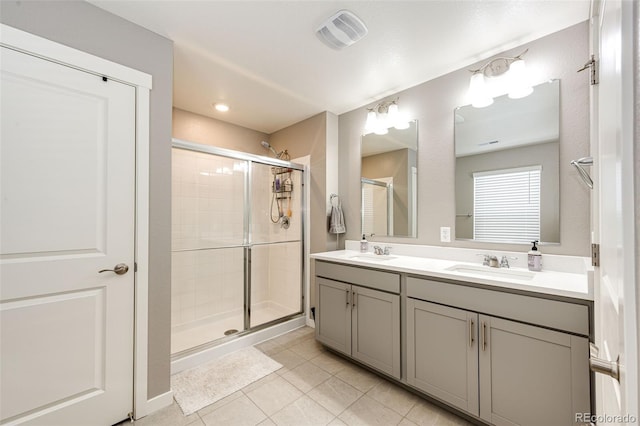 bathroom featuring a shower stall, tile patterned flooring, and double vanity