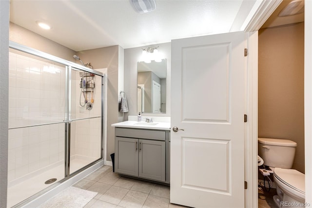 bathroom featuring a shower stall, tile patterned flooring, toilet, and vanity