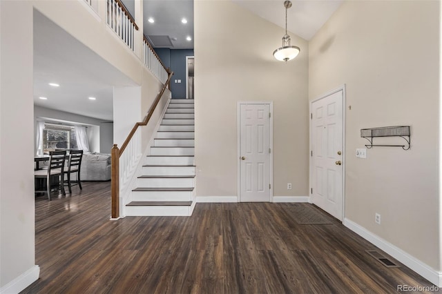 entrance foyer with dark hardwood / wood-style flooring and a high ceiling