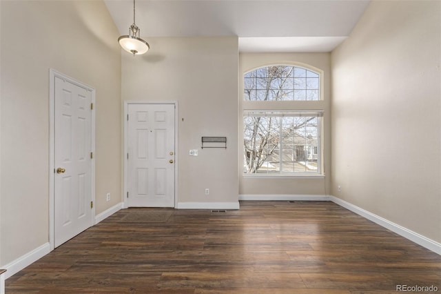 entrance foyer with a towering ceiling and dark hardwood / wood-style floors