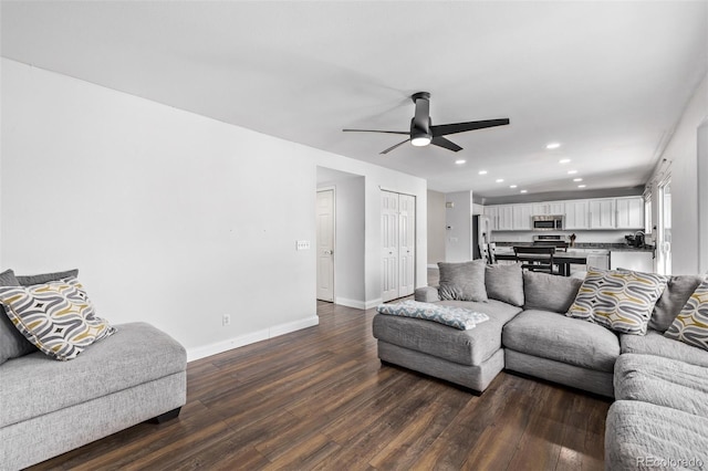 living room with ceiling fan and dark hardwood / wood-style flooring