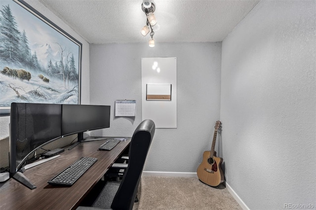 carpeted office featuring rail lighting and a textured ceiling