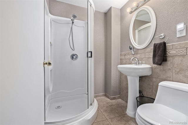 bathroom with tile walls, an enclosed shower, tile patterned flooring, and toilet