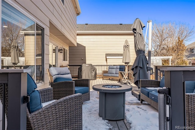 snow covered patio featuring an outdoor living space with a fire pit