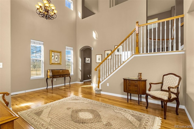 entryway with baseboards, visible vents, arched walkways, wood finished floors, and stairs