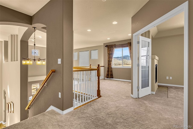 hall featuring recessed lighting, carpet, an upstairs landing, and a notable chandelier