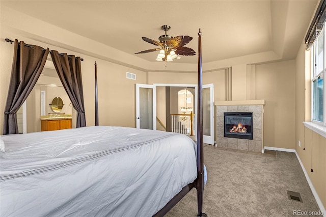 bedroom with carpet floors, a tray ceiling, and visible vents