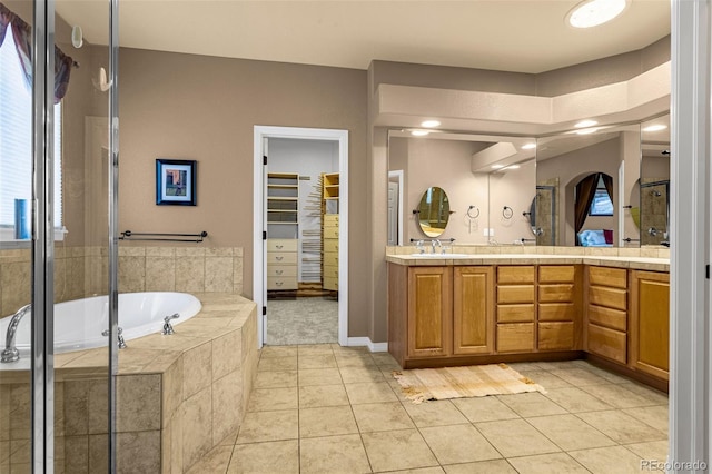 full bathroom with double vanity, tile patterned floors, a sink, and a shower stall