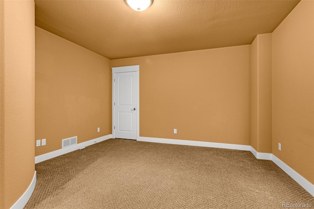 carpeted empty room featuring visible vents, a textured ceiling, and baseboards