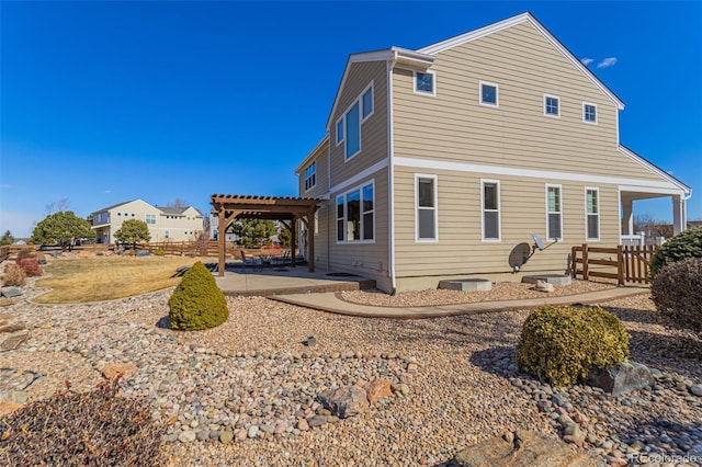 back of property with fence, a pergola, and a patio