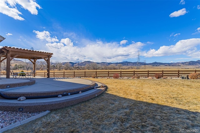 view of yard with fence, a mountain view, a pergola, and a patio