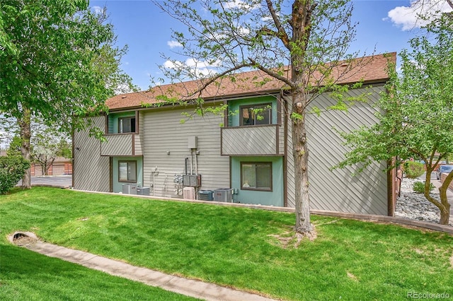 rear view of house featuring a yard and central AC