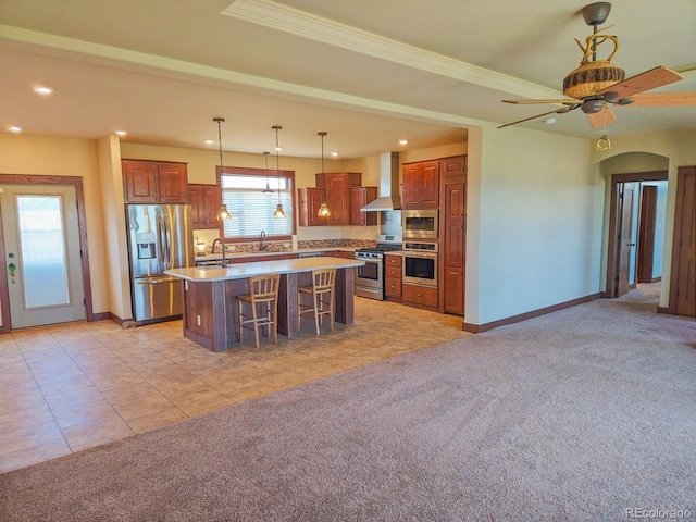 kitchen featuring a center island, appliances with stainless steel finishes, a kitchen breakfast bar, light colored carpet, and wall chimney range hood