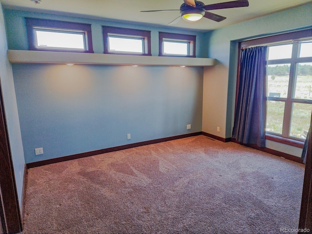 carpeted spare room featuring ceiling fan