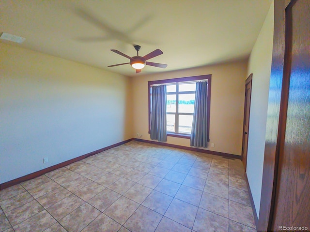 tiled empty room featuring ceiling fan