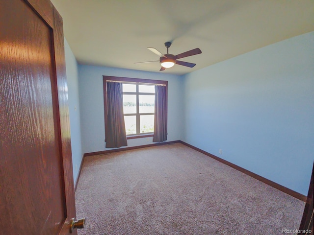 carpeted spare room with ceiling fan