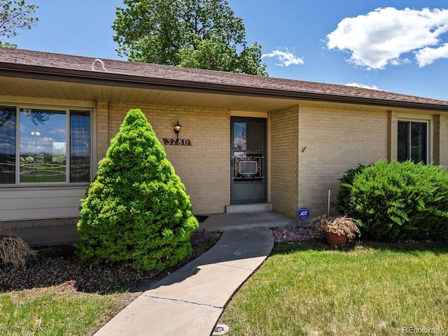 3780 W 66th Ave, Arvada, CO 80003 - entrance to property with brick siding, a lawn, and cooling unit