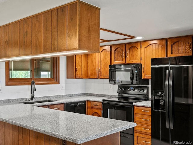 3780 W 66th Ave, Arvada, CO 80003 - kitchen featuring black appliances, a sink, brown cabinetry, a peninsula, and backsplash