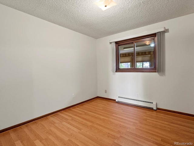 3780 W 66th Ave, Arvada, CO 80003 - empty room with a baseboard heating unit, light wood-style flooring, a textured ceiling, and baseboards