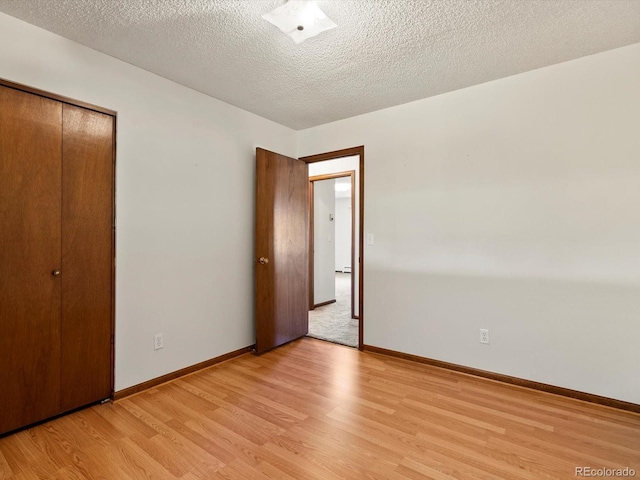 3780 W 66th Ave, Arvada, CO 80003 - unfurnished bedroom with light wood-type flooring, a textured ceiling, baseboards, and a closet