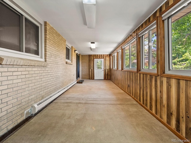 3780 W 66th Ave, Arvada, CO 80003 - hallway with a baseboard heating unit, brick wall, carpet flooring, and wood walls