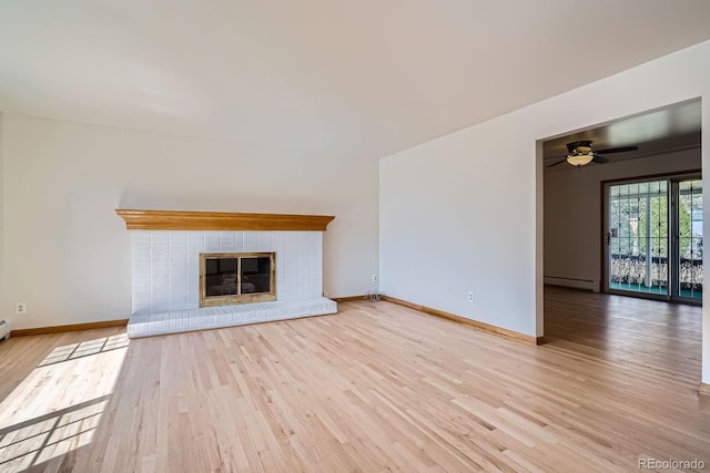 unfurnished living room featuring baseboards, baseboard heating, wood finished floors, and a fireplace