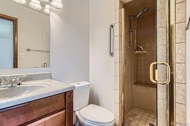 full bath with vanity, a shower stall, and toilet