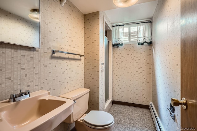 bathroom featuring a baseboard radiator, wallpapered walls, a stall shower, a sink, and toilet