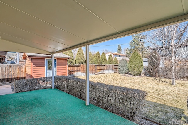 view of patio featuring an outbuilding, a fenced backyard, and a shed