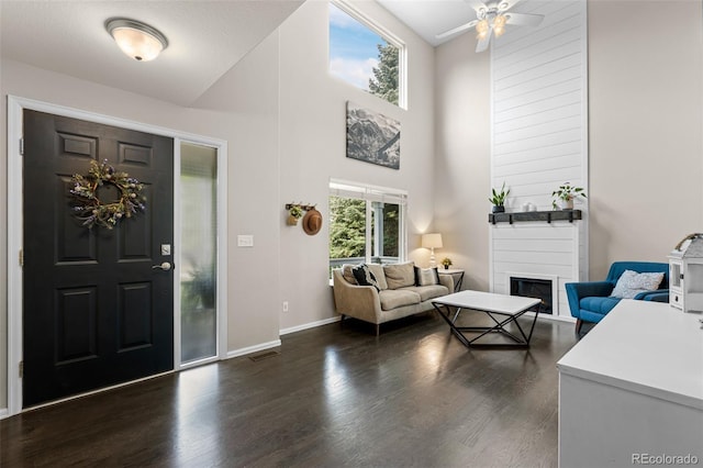 2066 Amber Ct, Erie, CO 80516 - foyer with dark wood-style floors, a fireplace, a ceiling fan, and a high ceiling