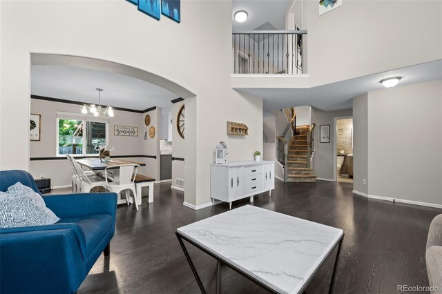 2066 Amber Ct, Erie, CO 80516 - living area featuring dark wood finished floors, stairway, a chandelier, and arched walkways