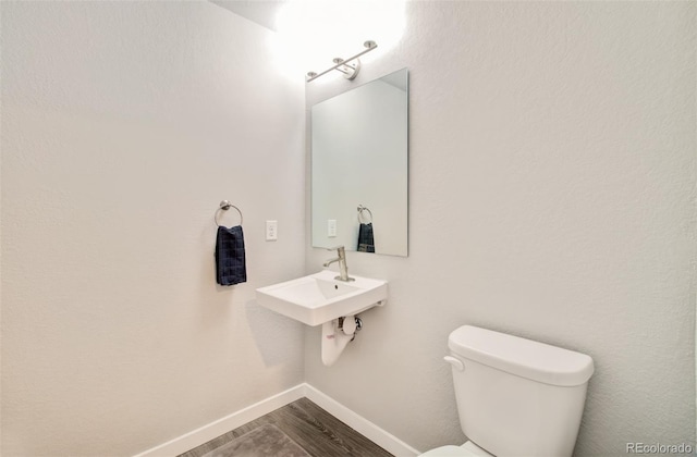5477 Passport Vw, Colorado Springs, CO 80922 - bathroom featuring toilet, wood finished floors, baseboards, and a sink