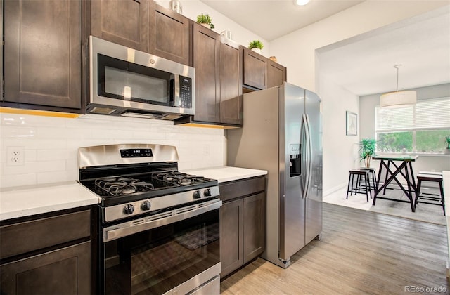 5477 Passport Vw, Colorado Springs, CO 80922 - kitchen with appliances with stainless steel finishes, light wood-type flooring, light countertops, dark brown cabinetry, and recessed lighting
