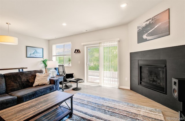 5477 Passport Vw, Colorado Springs, CO 80922 - living area with wood finished floors, a tile fireplace, recessed lighting, and baseboards