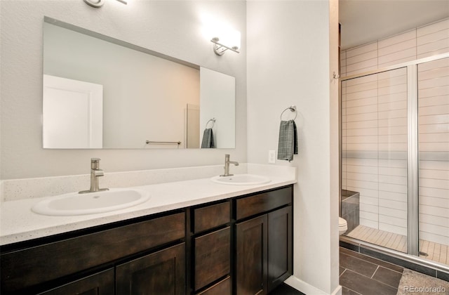 5477 Passport Vw, Colorado Springs, CO 80922 - bathroom with double vanity, a shower stall, toilet, and tile patterned floors