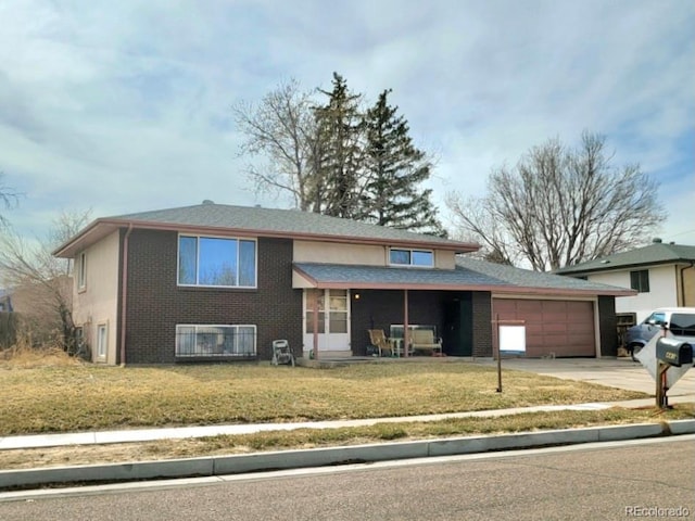 view of front of property with brick siding, a garage, driveway, and a front yard