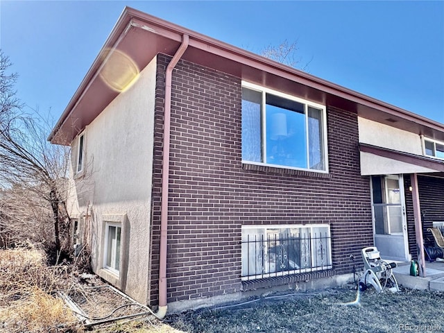 view of home's exterior featuring brick siding and stucco siding