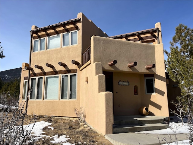 pueblo-style home with stucco siding