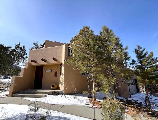 pueblo-style house featuring stucco siding