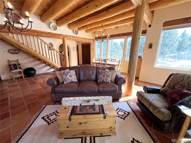 living room with a chandelier, beam ceiling, stairway, and dark tile patterned floors