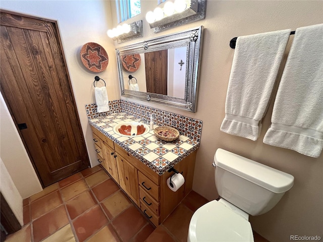 bathroom with toilet, tile patterned floors, and vanity