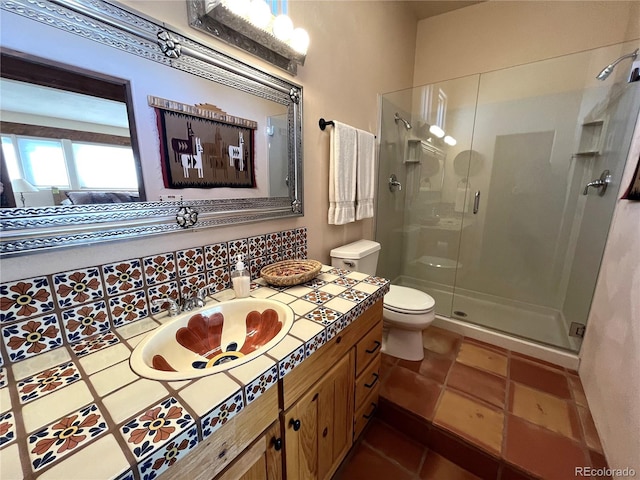 bathroom featuring toilet, vanity, a shower stall, tile patterned floors, and ensuite bath