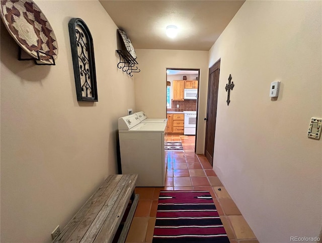 hallway with washer and clothes dryer and tile patterned floors