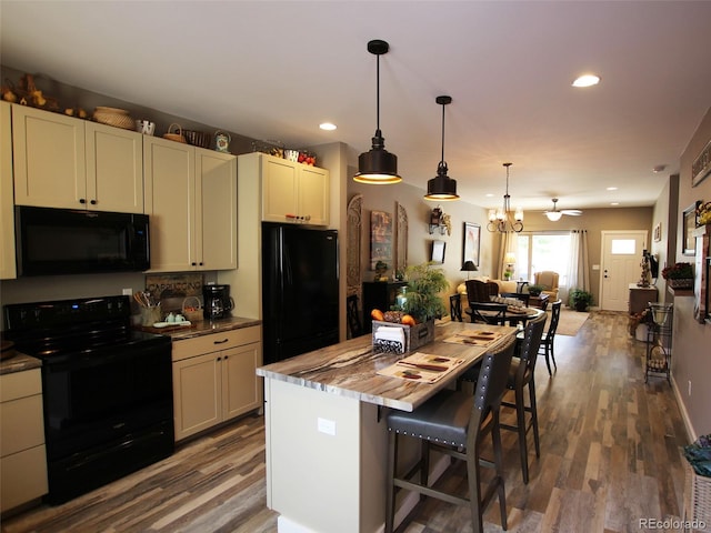 219 Summitview Ln, Poncha Springs, CO 81201 - kitchen with black appliances, recessed lighting, wood finished floors, open floor plan, and a chandelier