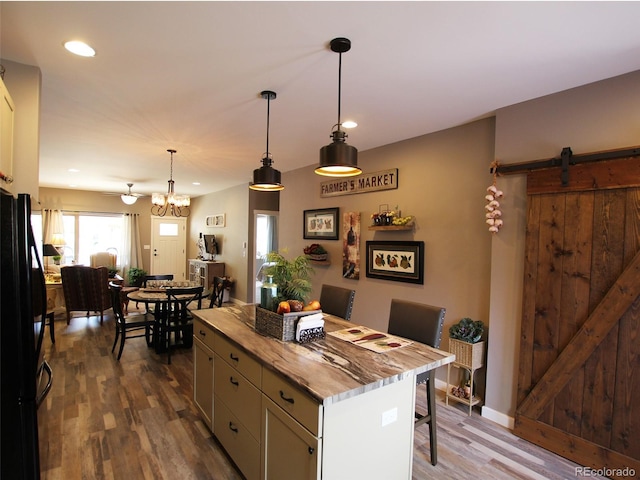 219 Summitview Ln, Poncha Springs, CO 81201 - kitchen featuring freestanding refrigerator, a breakfast bar area, dark wood finished floors, a kitchen island, and decorative light fixtures