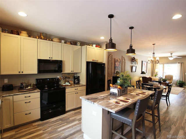 219 Summitview Ln, Poncha Springs, CO 81201 - kitchen with black appliances, light wood-style flooring, recessed lighting, decorative light fixtures, and a breakfast bar area