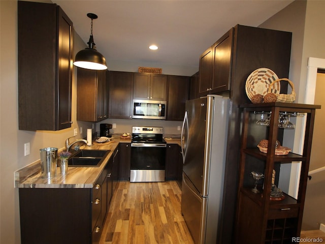 219 Summitview Ln, Poncha Springs, CO 81201 - kitchen with stainless steel appliances, light wood-style floors, dark brown cabinetry, light countertops, and decorative light fixtures