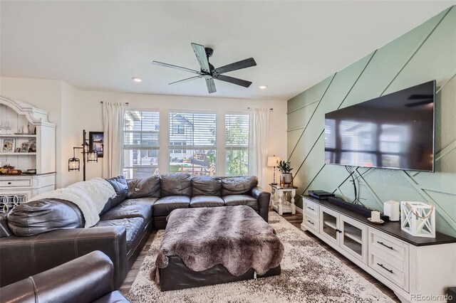 living room featuring wood-type flooring and ceiling fan