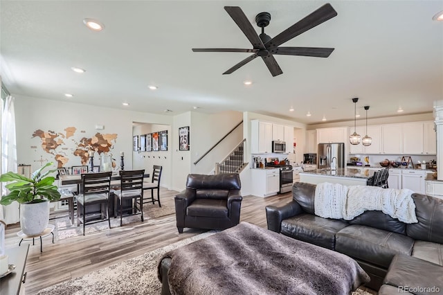 living room featuring ceiling fan and light wood-type flooring